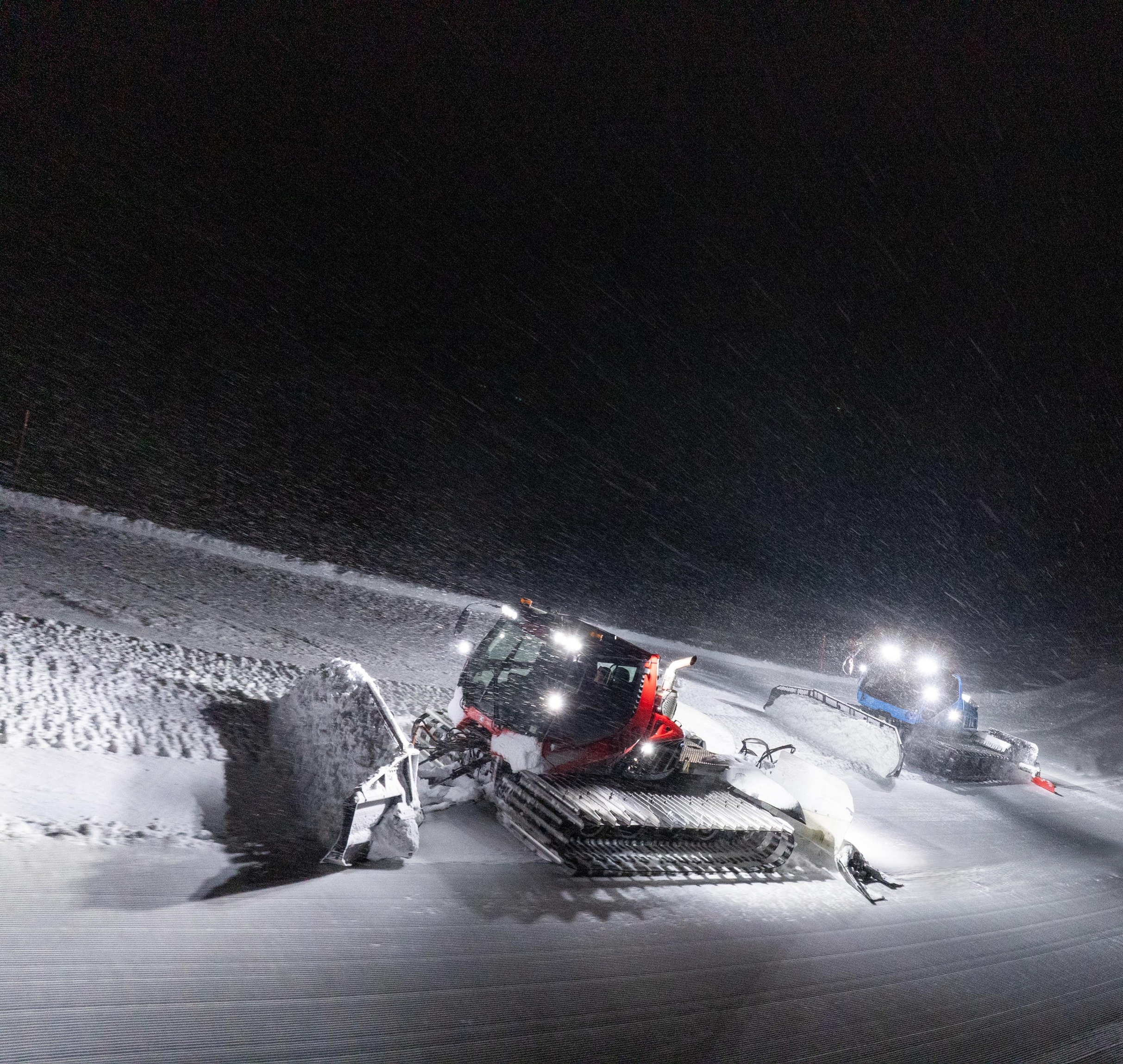 Pistenraupe bei Nacht im Schneetreiben